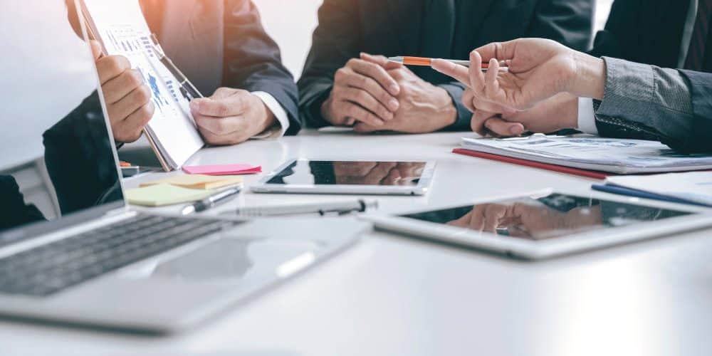 Cropped,Shot,Group,Of,Businesspeople,Using,Graph,Chart,And,Computer